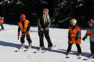 Instruktorka Lu a růžoví pokročilí lyžaři.