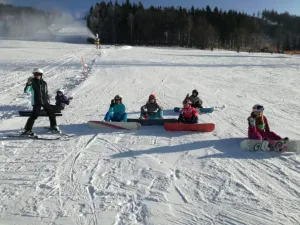 Snowboarďáci a lyžaři