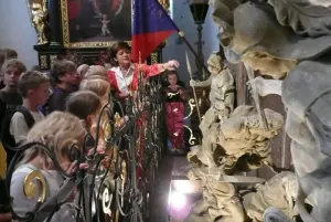 Paní Nováková ukazuje místo, kde došlo k zavraždění knížete.